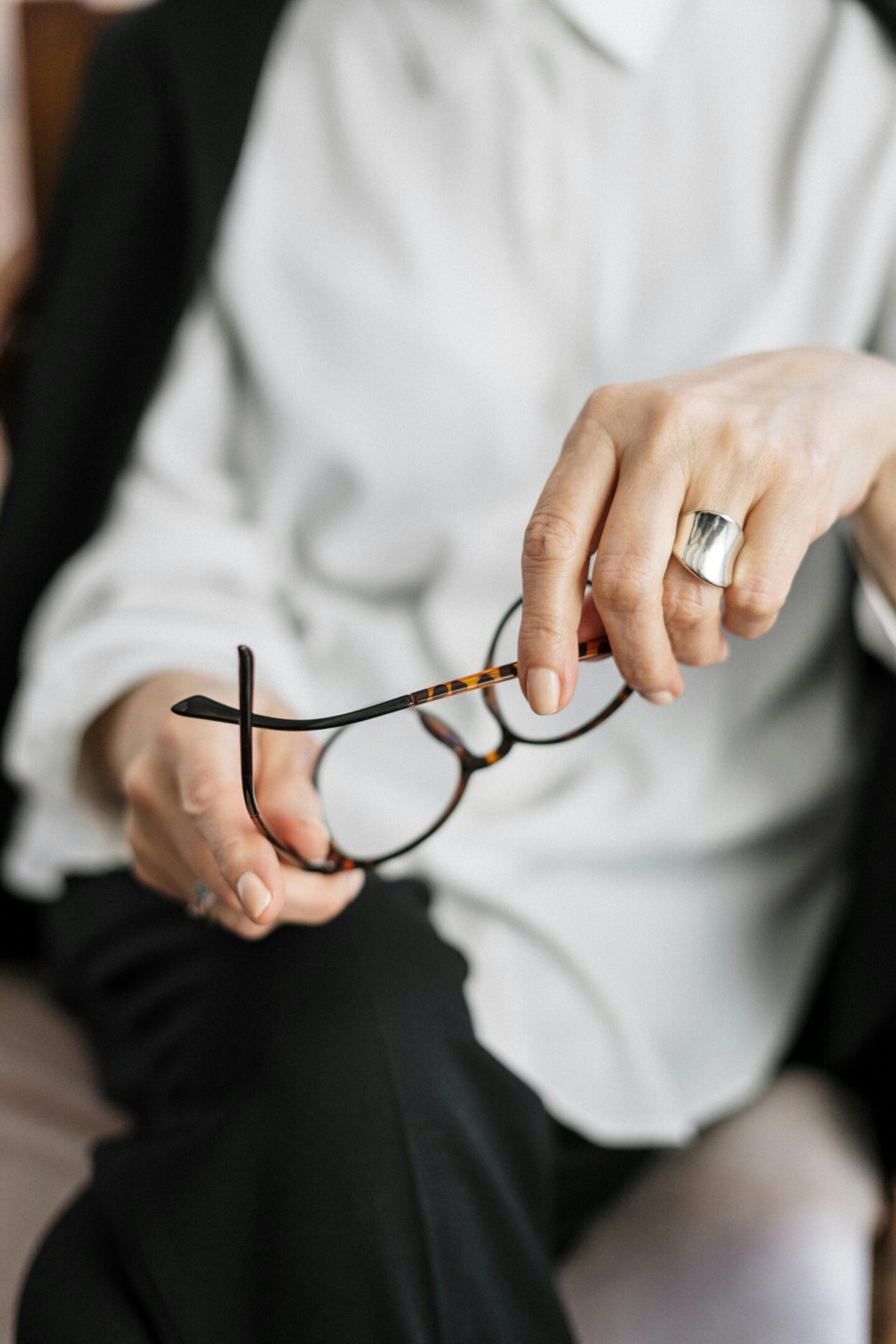 A person holding glasses in their hands.